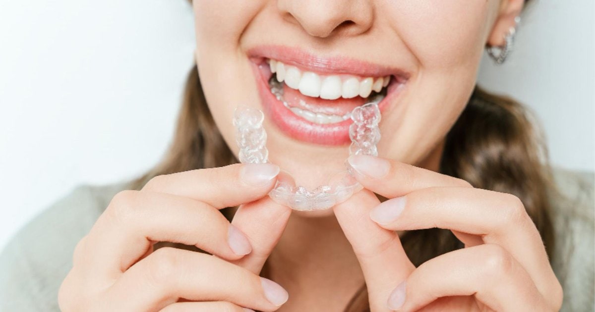 Patient holding Invisalign clear aligner tray in Gordon